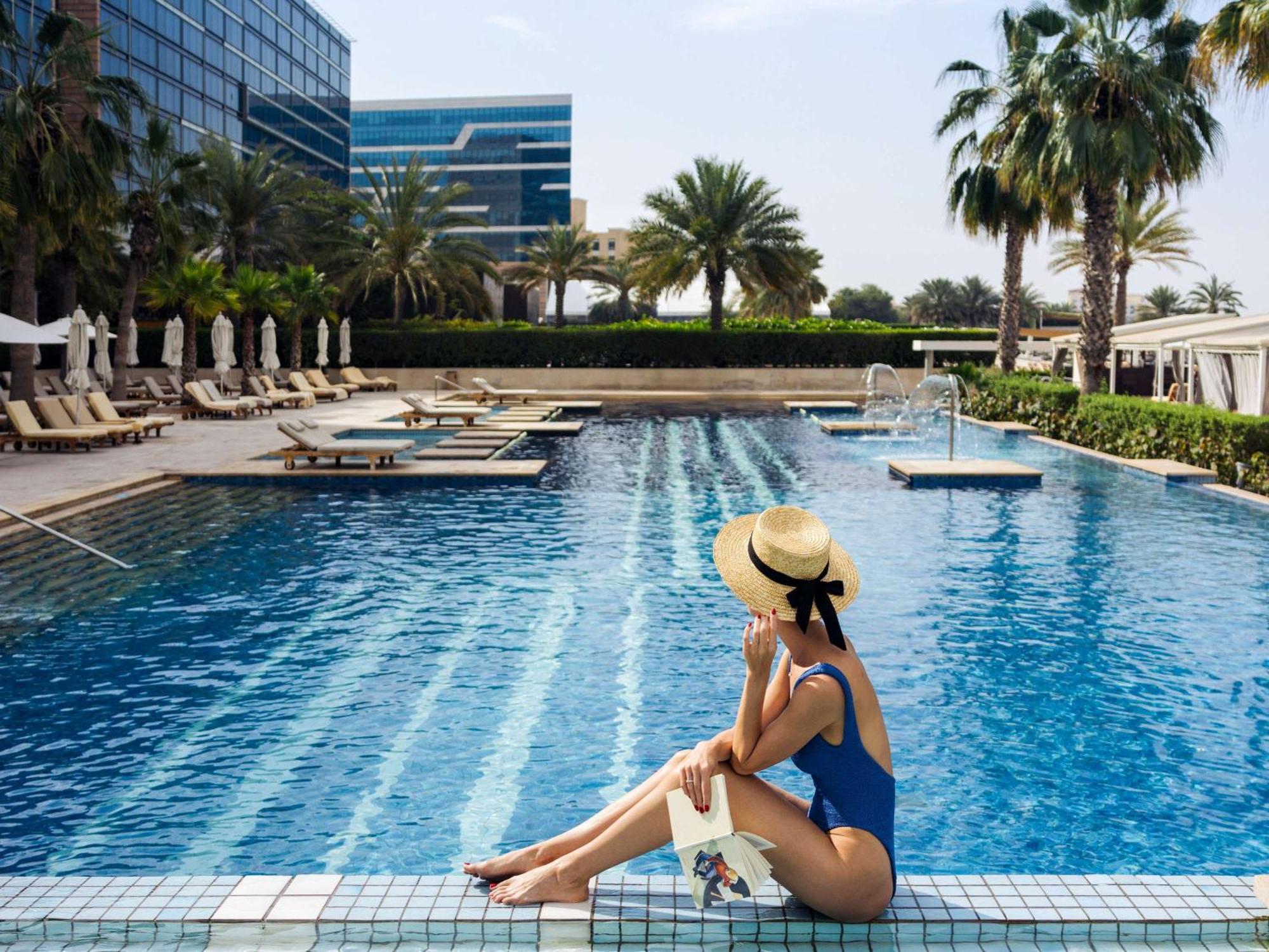 فندق فيرمونت باب البحر أبو ظبي المظهر الخارجي الصورة A woman sunbathing at a pool